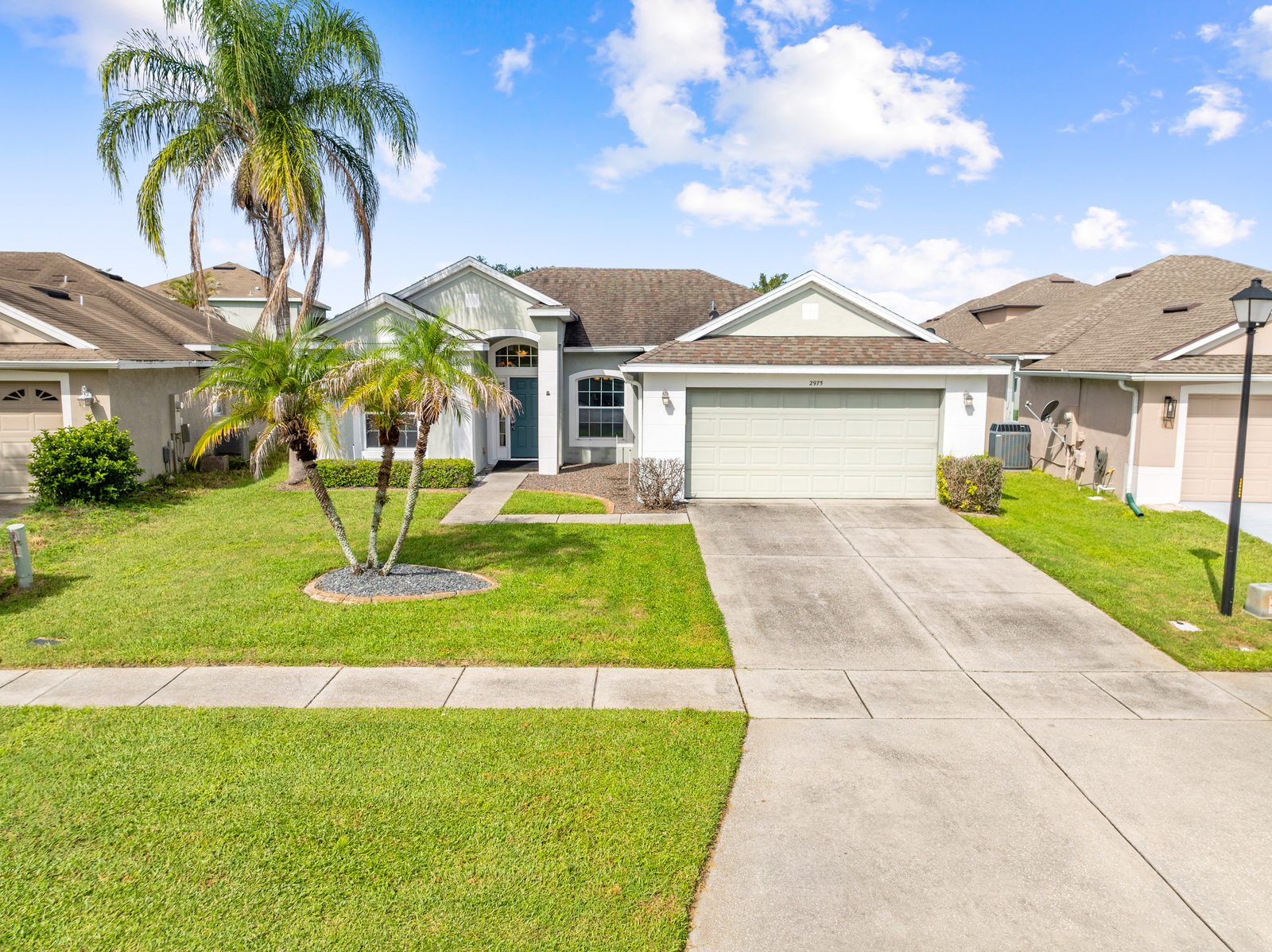 Front elevation with palm trees and two-car garage