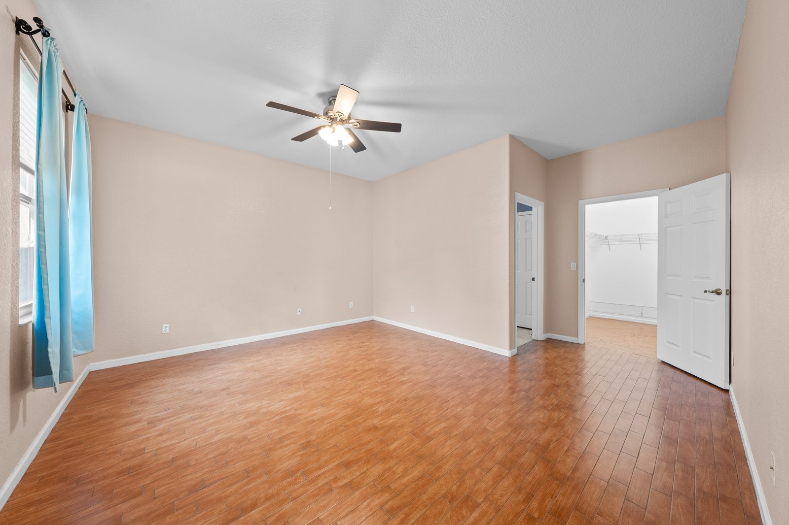Primary bedroom with wood flooring